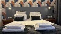 Un dormitorio con una cama grande con dos almohadas. en Hotel Le Bourgogne, en Évian-les-Bains