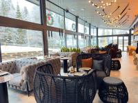 un restaurante con sillas de mimbre, mesas y ventanas en Shypit Spa&Resort, en Pilipets