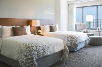 a hotel room with two beds and a chair at Renaissance Santo Domingo Jaragua Hotel & Casino in Santo Domingo
