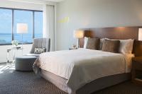 a bedroom with a large bed and a chair at Renaissance Santo Domingo Jaragua Hotel & Casino in Santo Domingo