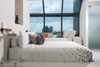 a white bed in a room with a large window at Renaissance Santo Domingo Jaragua Hotel & Casino in Santo Domingo