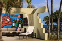 a couch and a chair in front of a painting at Renaissance Santo Domingo Jaragua Hotel & Casino in Santo Domingo