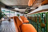 a row of orange chairs in a restaurant with tables at Laguna Beskidów Resort - Apartament Simple Comfort in Zarzecze