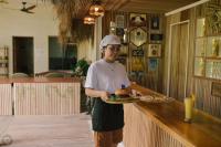 a man holding a plate of food on a counter at Patrick's on the Beach Resort in General Luna