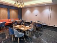 Rivana Boutique Hotel في طشقند: غرفة طعام مع طاولات وكراسي وأريكة