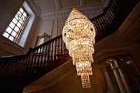 ein großer Kronleuchter hängt von einer Treppe in einem Gebäude in der Unterkunft Plas Nanteos Mansion in Aberystwyth