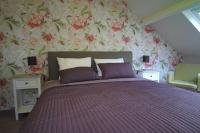 a bedroom with a bed with a floral wallpaper at Bed &amp; Breakfast De Kleine Magnolia in Tessenderlo