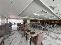 Un restaurante con mesas y sillas en una sala. en Grand Travello Hotel Bekasi, en Kedaung
