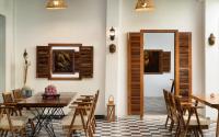 a dining room with a table and chairs and a mirror at The Community - Siem Reap in Siem Reap