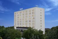 Un edificio alto y blanco con árboles delante. en Fairfield by Marriott Ahmedabad, en Ahmedabad