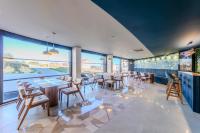 ein Restaurant mit Tischen und Stühlen und großen Fenstern in der Unterkunft Heaven Premium Hotel Restaurant & Airport Shuttle in Arnavutköy