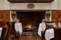 uma lareira na sala de jantar de um restaurante com mesas e cadeiras em The Chemists Club Hotel em Nova Iorque