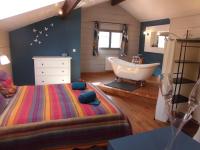 1 dormitorio con bañera, 1 cama y lavamanos en La Sauvanière, en Menée