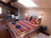 1 dormitorio con 1 cama grande con manta a rayas en La Sauvanière, en Menée