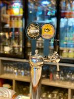 Un dispensador de bebidas en un bar con botellas de alcohol. en Hôtel Saint-Roch, Saint-Ybard, en Saint-Ybard