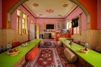 sala de estar con paredes de color verde y rosa en LIGHTWORKERS Hostel & Cafe, en Kalgha