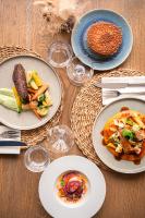 ラ・ベルヌリー・アン・レッツにあるHôtel de charme & SPA Le Grand Largeの木製テーブル(食べ物、ワイングラス付)