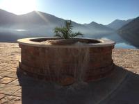 una fuente de ladrillo con una planta en medio de un lago en Apartment Radimiri, en Kotor