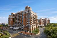 a large building in a city with trees at ITC Grand Chola, a Luxury Collection Hotel, Chennai in Chennai
