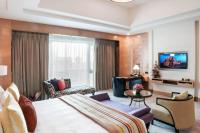 a hotel room with a large bed and a living room at ITC Grand Chola, a Luxury Collection Hotel, Chennai in Chennai