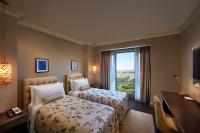 a hotel room with two beds and a desk and a window at ITC Grand Chola, a Luxury Collection Hotel, Chennai in Chennai