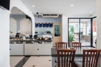 een keuken met houten stoelen en een tafel bij Kokotel Pattaya North Beach in Noord Pattaya