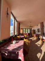 a living room with a table and chairs and windows at Casa Leone Hotel&Restaurant in Popova Shapka