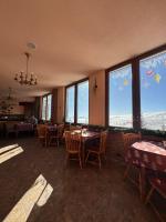 a restaurant with tables and chairs and large windows at Casa Leone Hotel&Restaurant in Popova Shapka