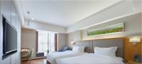 a hotel room with a bed and a flat screen tv at 花之筑酒店常德步行街店 in Changde