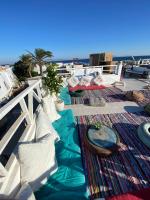 un patio con almohadas blancas y una alfombra en Havana House, en Dahab