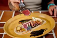 a person holding a piece of meat on a fork at Murrieta Hot Springs Resort in Murrieta