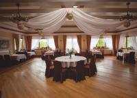 een eetkamer met tafels, stoelen en gordijnen bij Noclegi i restauracja Zajazd Pod Skałą in Jasło