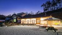 ein Gebäude mit einem Picknicktisch und einem Sonnenschirm in der Unterkunft Gangneung ggabinejip hanok pension in Gangneung