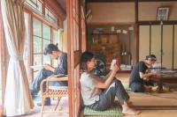 a group of people sitting in a room reading at Guesthouse SETOUCHI LIFE in Kure