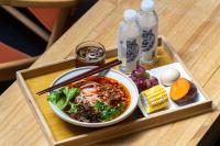 una bandeja de comida con un tazón de sopa y verduras en Dali Porcelain Inn, en Antigua Ciudad de Dali