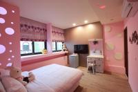 a pink bedroom with a bed and a television at Fasiter B&amp;B train station in Hualien City