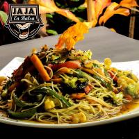 een bord met noedels en groenten op een tafel bij Balsa Surf Camp in Montañita