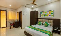 a bedroom with a bed and a desk with a chair at Treebo The Golden Sands, Bistupur in Jamshedpur