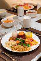 滨江万璟酒店 One Gem Hotel في هايكو: طبق طعام يحتوي على المعكرونة والبيض على الطاولة