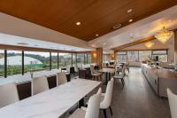 een restaurant met tafels en stoelen en grote ramen bij UE Garden Resort in Chiba
