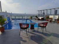 un patio con sillas y una piscina en un edificio en Sylhet Paradise Inn, en Sylhet