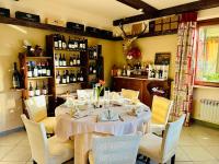 een eetkamer met een tafel met stoelen en wijnflessen bij Relax Della Valle in Coassolo Torinese