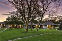 Un complejo turístico con un árbol y algunos edificios. en Protea Hotel by Marriott Oudtshoorn Riempie Estate, en Oudtshoorn
