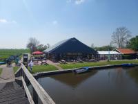 een gebouw met een boot in het water naast een rivier bij Wylde Swan in Sprong