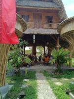 un bâtiment avec des gens assis sur des chaises devant dans l'établissement JinengBali Eco Lodge, à Tegalalang