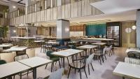 una vista interior de un restaurante con mesas y sillas en Mercure Madiun, en Madiun