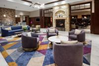 vestíbulo con mesas de sillas y chimenea en Sheraton St Paul Woodbury Hotel, en Woodbury