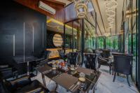 een restaurant met tafels, stoelen en ramen bij High Tree Resort, Krabi in Ao Nam Mao