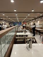 Un restaurante con muchas mesas y gente de pie en el mostrador. en The Paradise Kingdom, en Kanchipuram