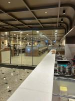 Un restaurante con un largo mostrador con paredes de cristal. en The Paradise Kingdom, en Kanchipuram